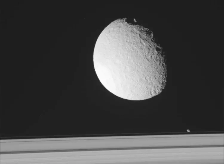 Tetis flotando sobre los anillos de Saturno