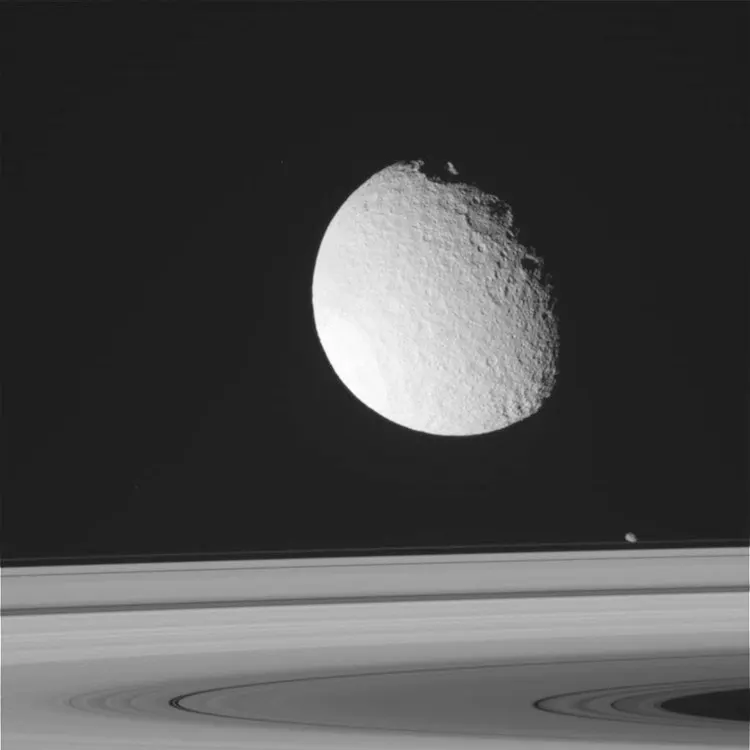 Tetis flotando sobre los anillos de Saturno